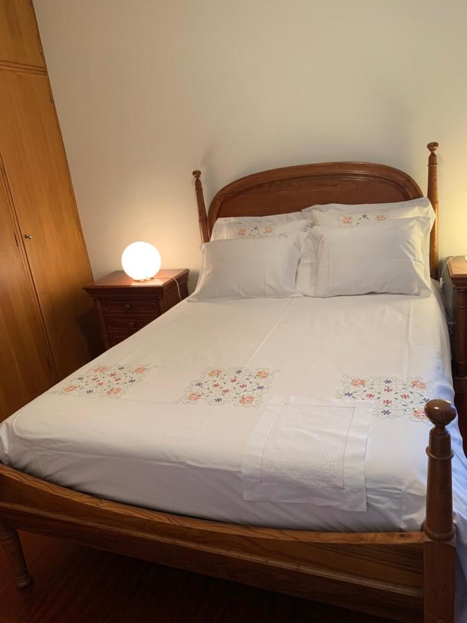 Quarto de casal com cama em madeira e vista para o jardim