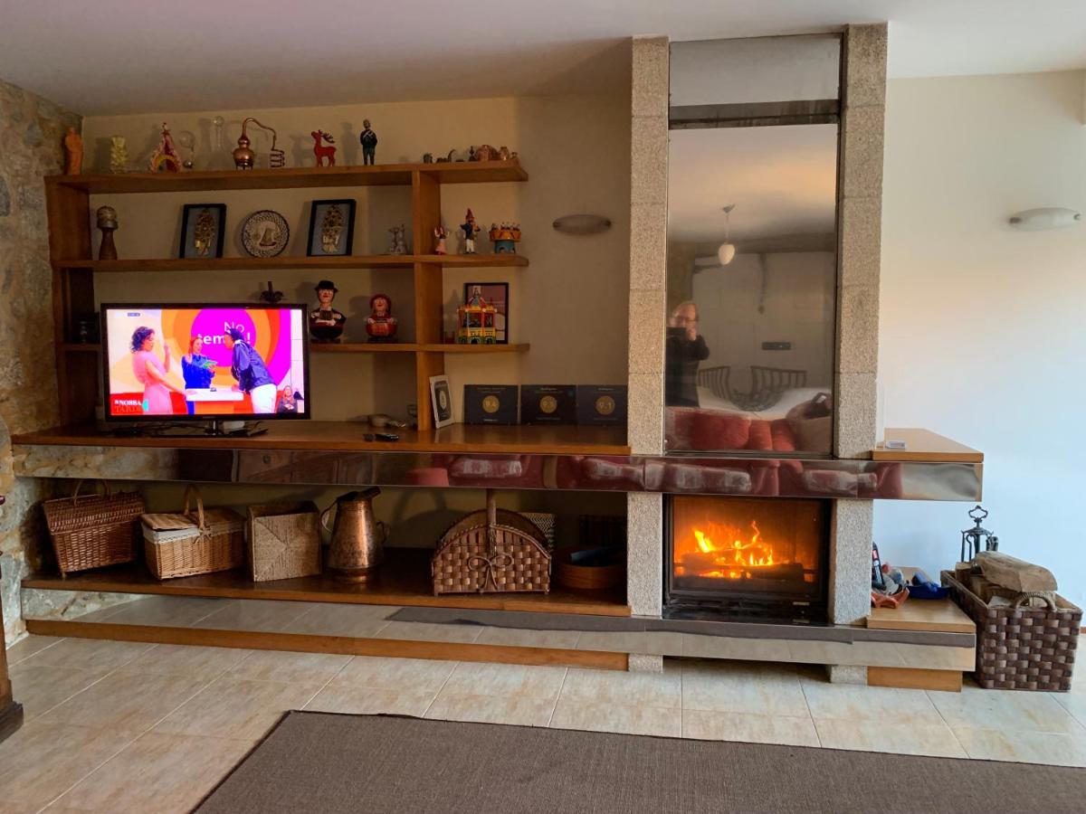 Sala aconchegante com lareira em pedra e televisão
