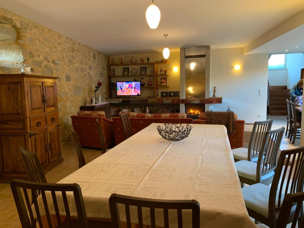 Sala de refeições com mesa larga e televisão ao fundo