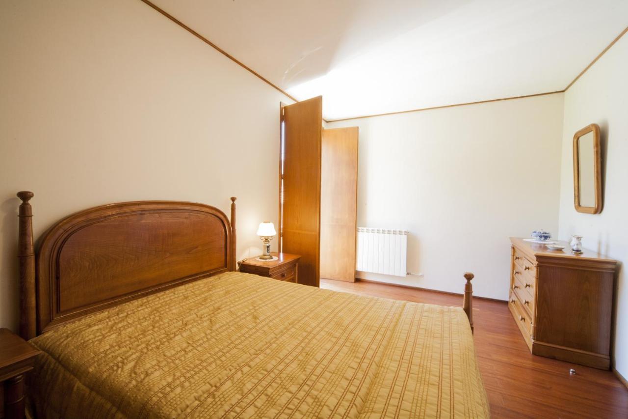 Quarto de casal com colcha amarela e mobiliário em madeira