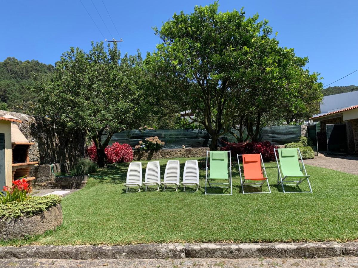 Jardim relvado com cadeiras à sombra na Casa Praia e Campo