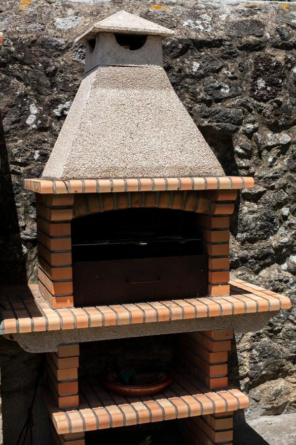 Churrasqueira em pedra granítica encostada a muro antigo