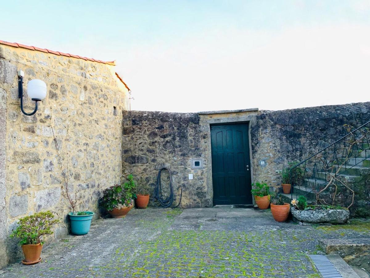Pátio interior calcetado com muros de pedra e vasos