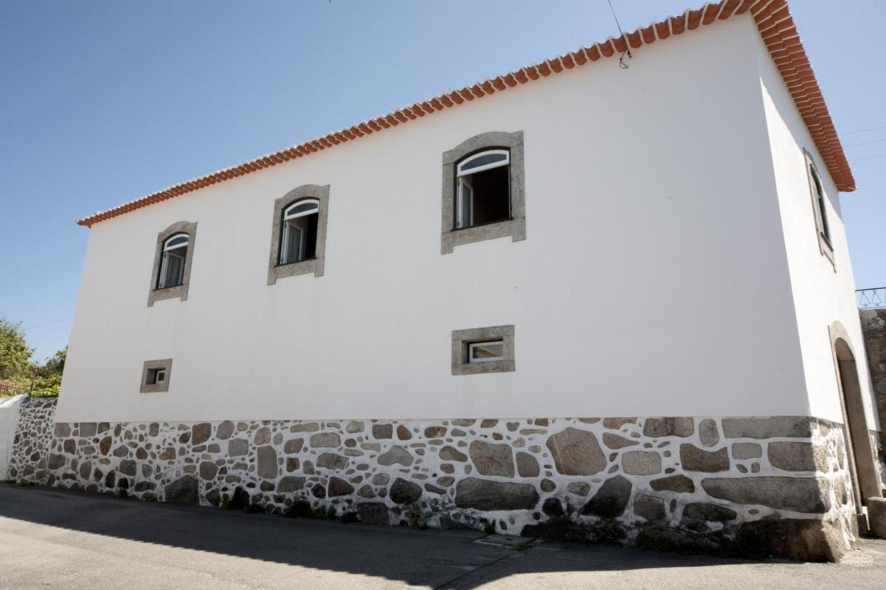 Fachada branca da casa com telhado de telha vermelha